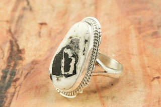 White Buffalo Turquoise set in Sterling Silver Ring. This Beautiful Stone is formed from the minerals Calcite and Iron. It is mined near Tonopah Nevada. Created by Navajo Artist Larson Lee. Signed by the artist.